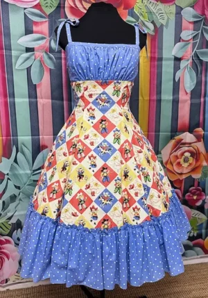 Hot Ginger® Howdy Darling Dress – handmade vintage-inspired dress with colourful cowboy and patchwork print, blue polka dot accents, and full gathered skirt.