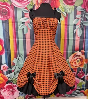 Front view of the Hot Ginger “Pumpkin Spice” Dress – orange and black check vintage-style dress with full skirt and black bow accents.